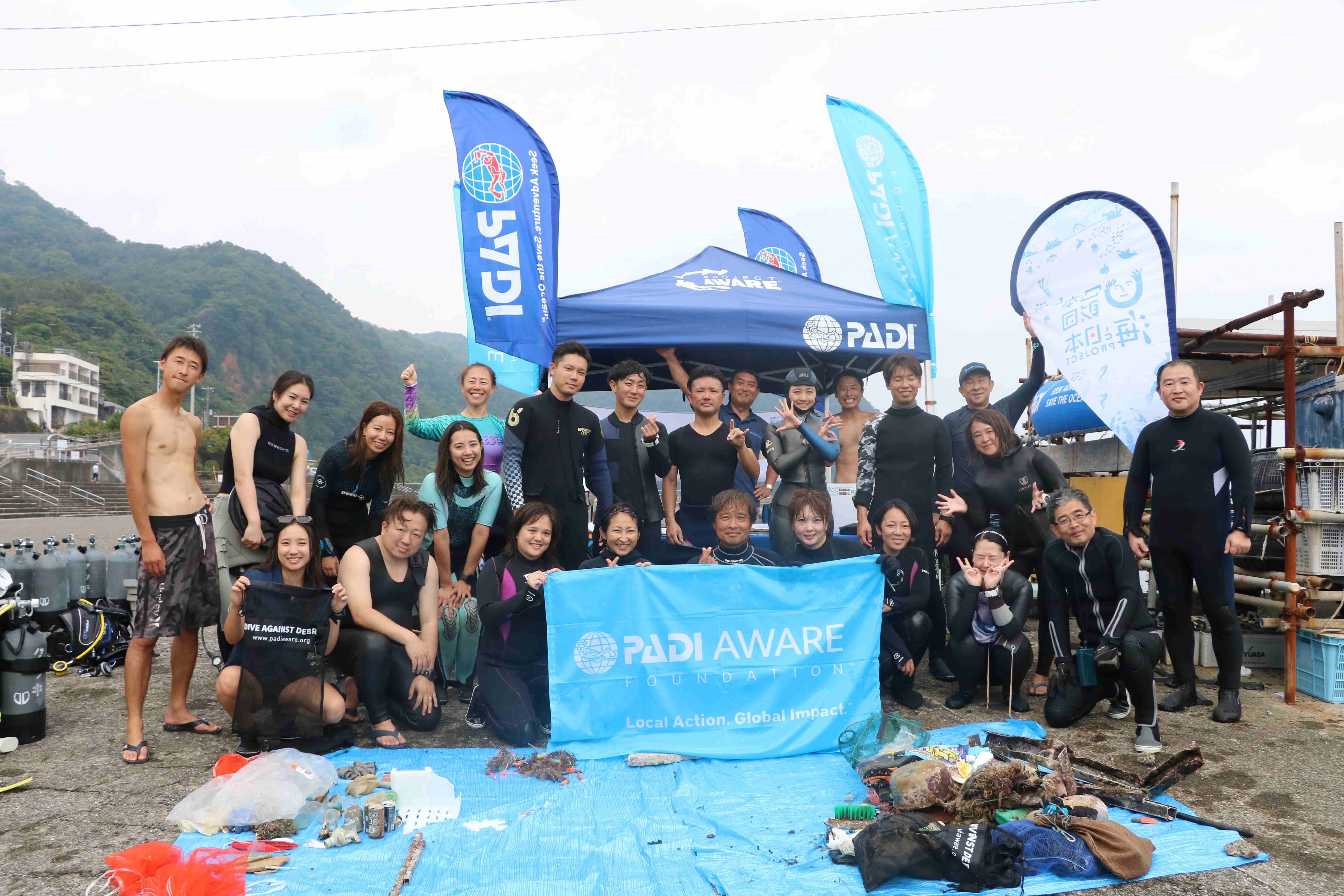 a group of divers holding up padi aware flag