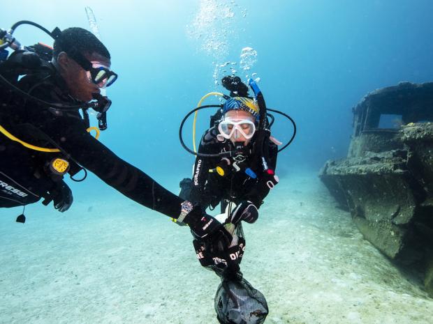 two divers picking up trash