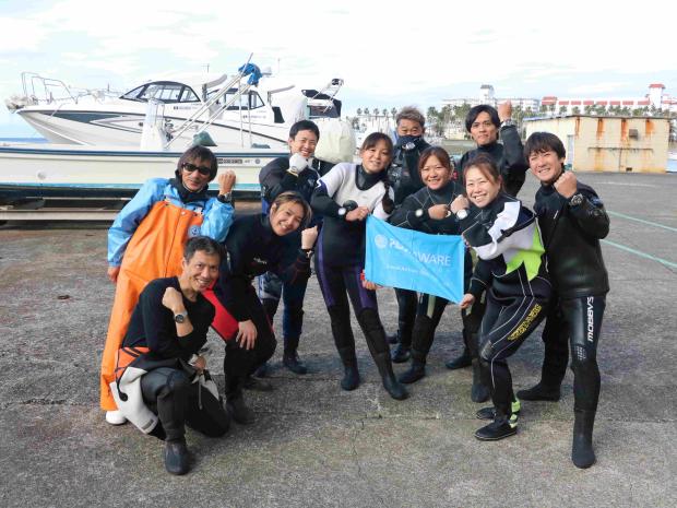 a group of divers posing before going into the water