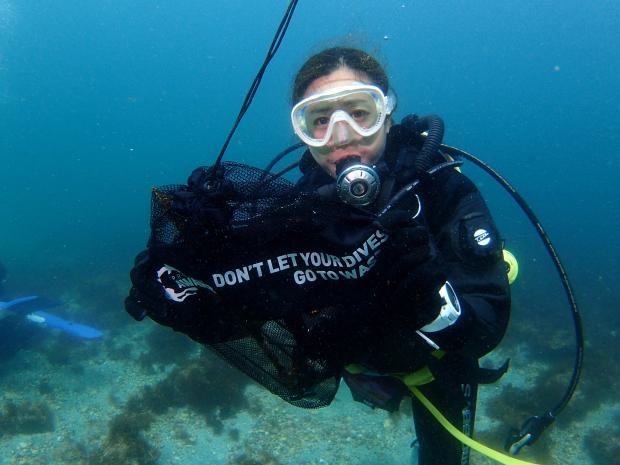 a diver holding a underwater clean up bag