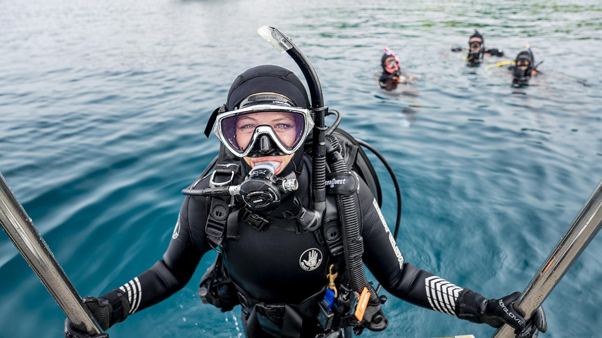 Cold water scuba diver with other divers