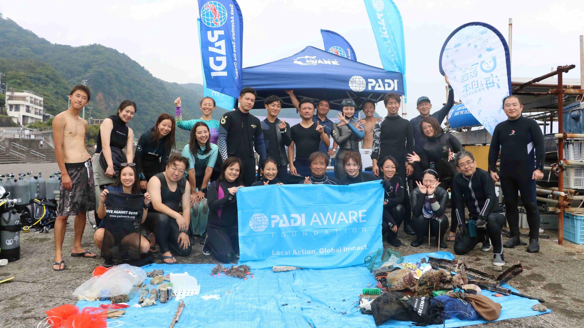 a group of divers holding up padi aware flag
